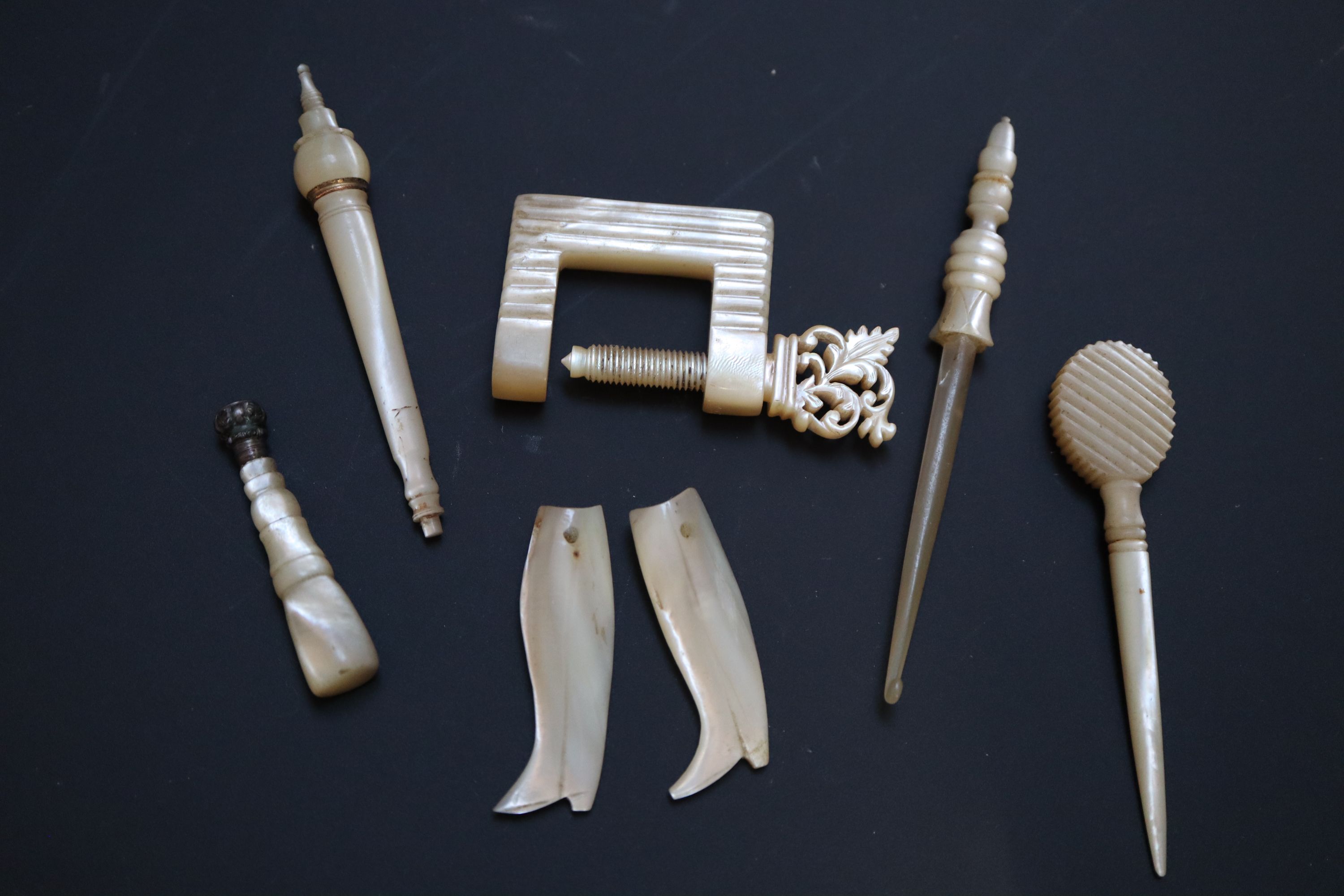 Four 19th century Palais Royale mother of pearl needle cases with gilt mounts, largest 9cm,